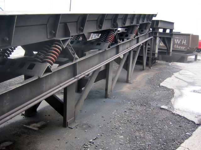 Conveyor system moving rebar into portable container