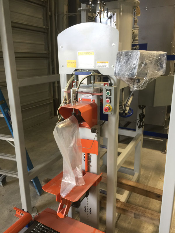 Valve bag filling machine air packer used to fill 50 lb inclusion bags with roadway pigment powder
