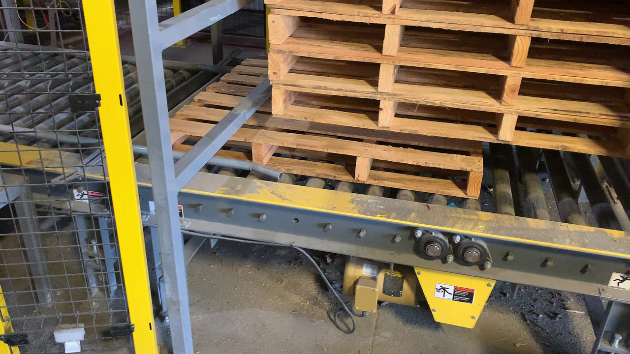 Empty pallet being dispensed from automatic pallet dispenser