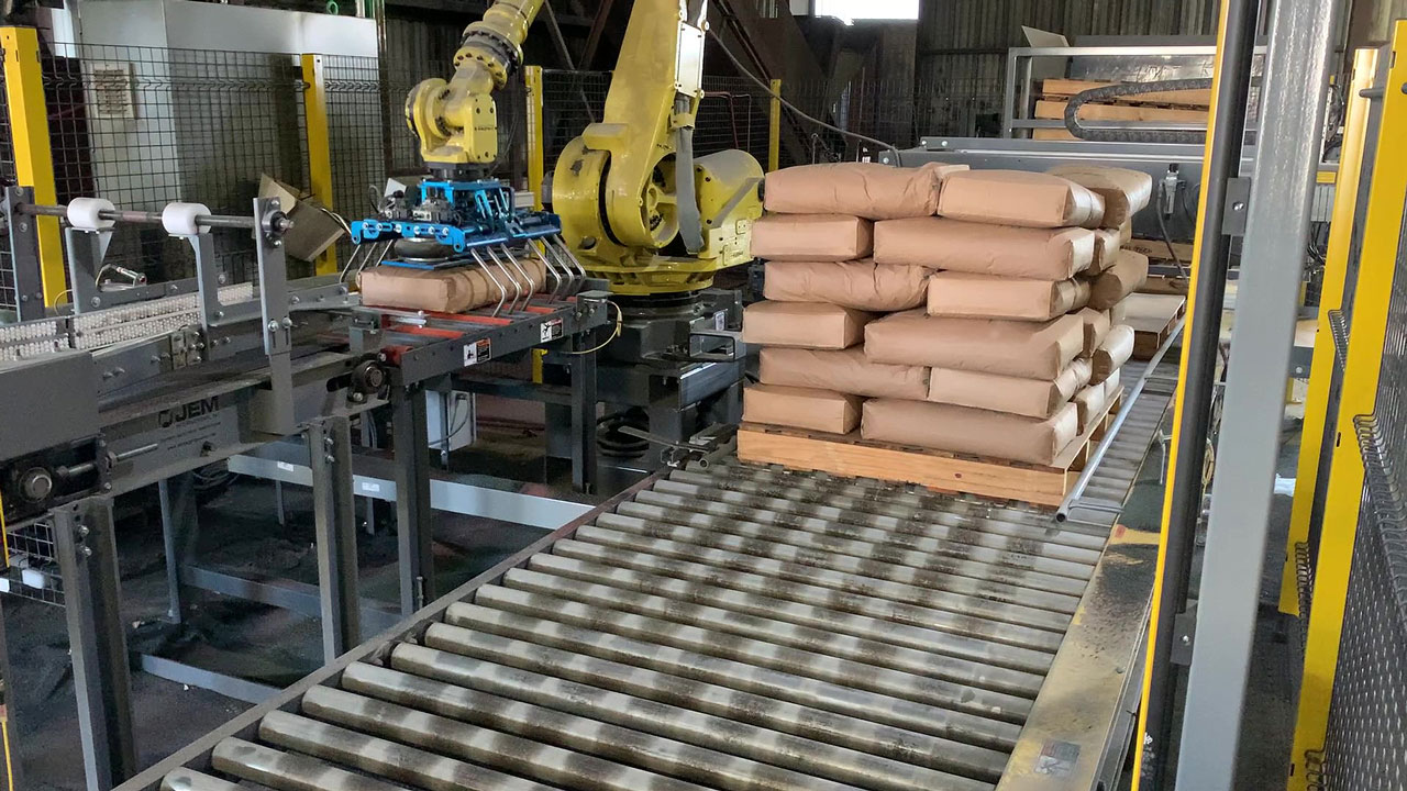 Additional view of Fanuc robot picking up 100 lb. bag of minerals using bag gripper tool and stacking on an almost full pallet