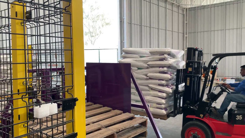 fork truck retrieving wrapped pallet of 40kg bags of livestock feed