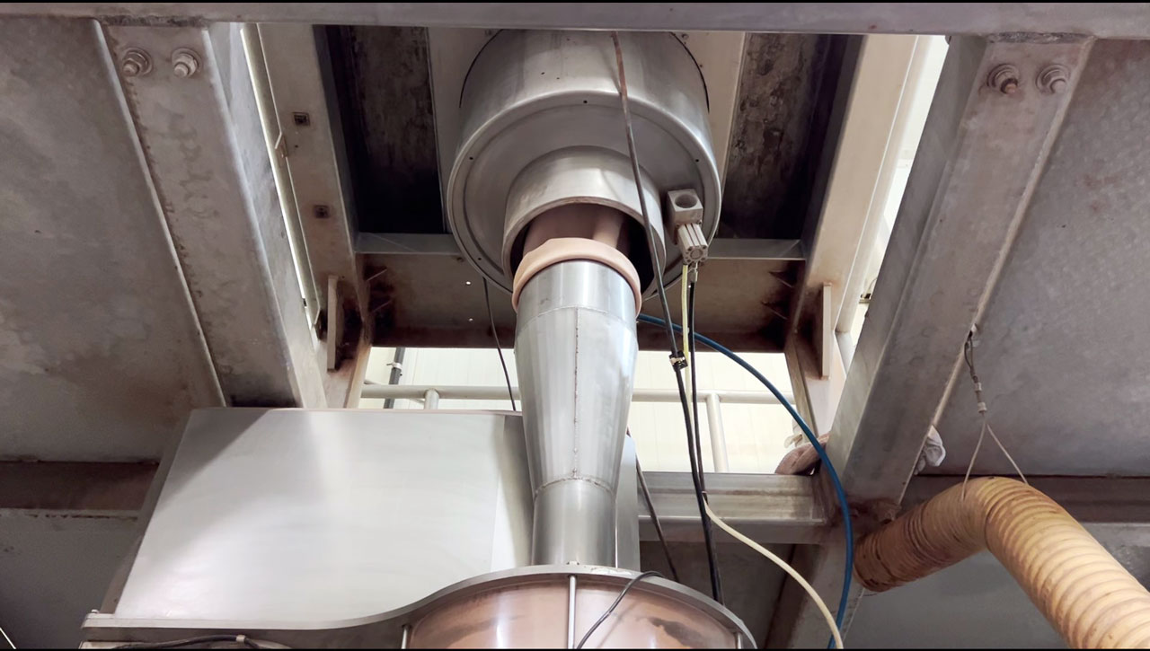 Bottom view of IBC container discharge station and connection to powder packing machine