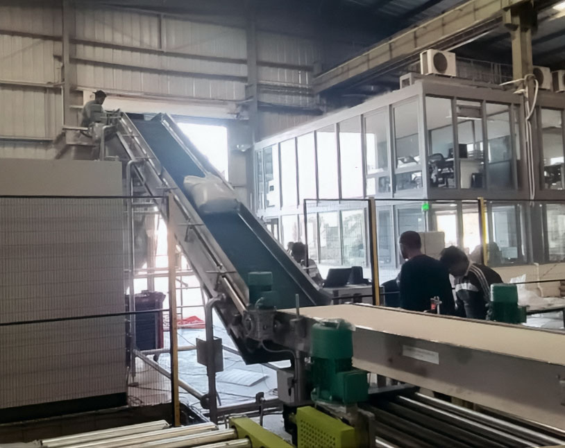 50 lb bag of chemical powder going up incline conveyor to bag opening machine