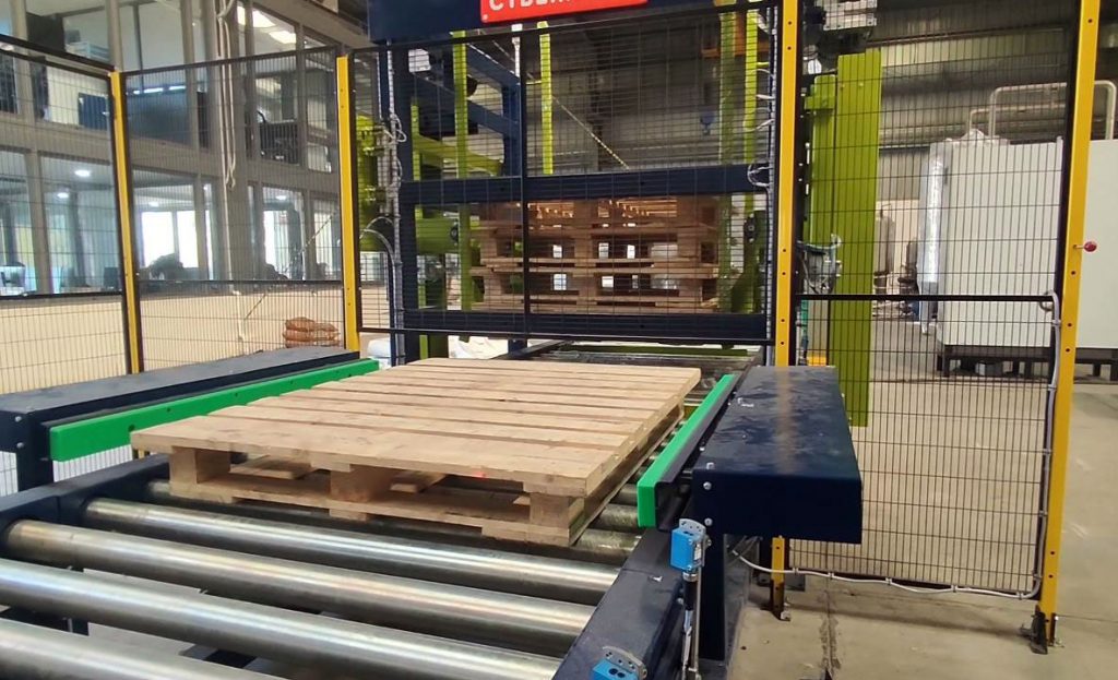 empty pallet being squared up before entering automatic pallet collection system