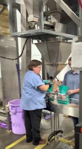 Small bag filler weighing and filling coffee into pouches.