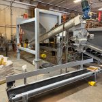auger fed open mouth bagging machine and system for sticky products like asphalt cold patch