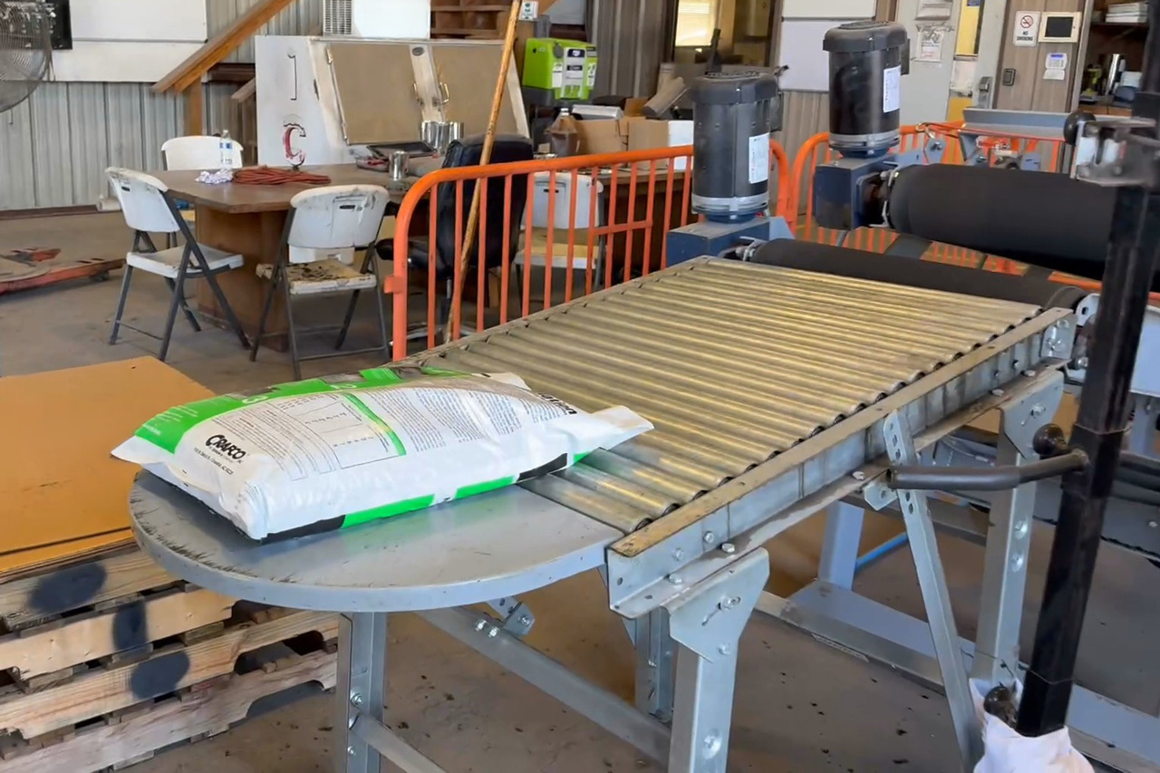 bag of asphalt cold patch on gravity roller accumulation table
