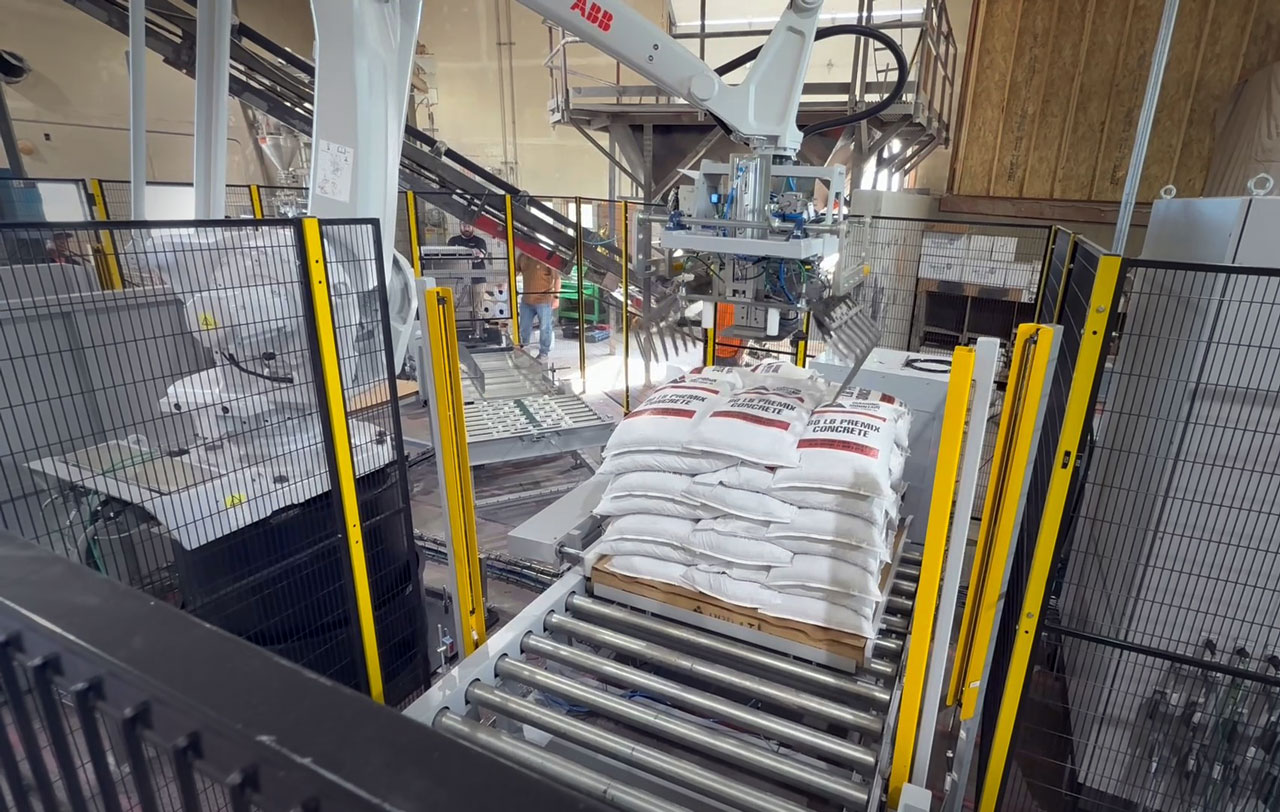 ABB robot dropping bag of premix concrete onto pallet