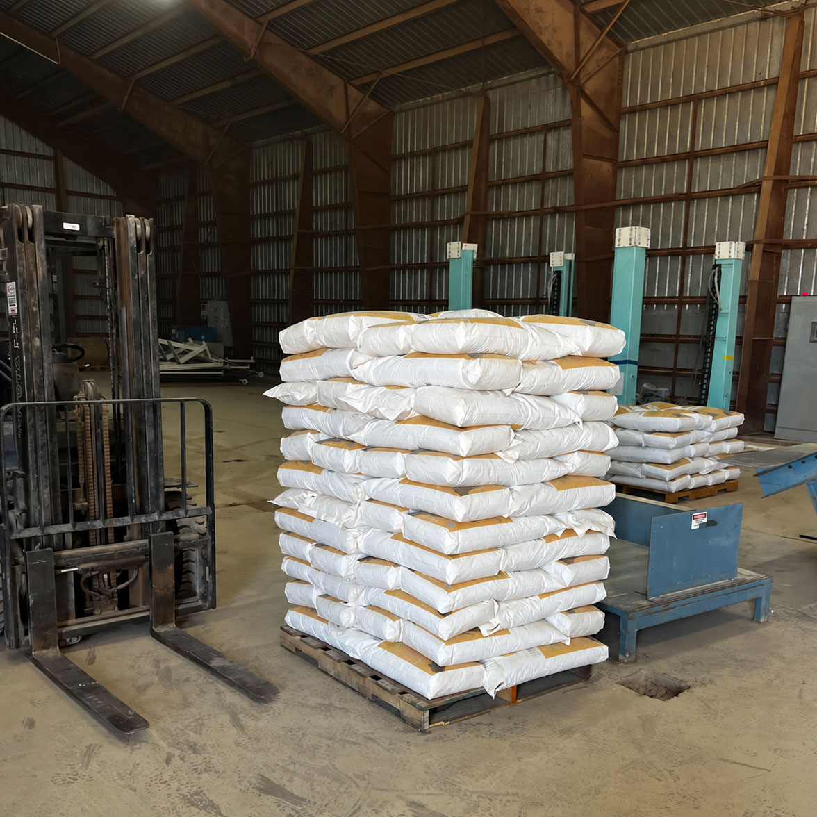 bags of granular absorbent on a pallet next to a fork lift